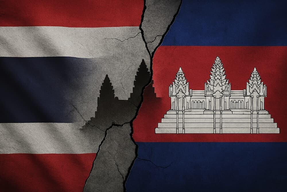 タイとカンボジアの国旗が睨み合うように配置され、その間にひび割れた世界遺産の寺院のシルエットが描かれているイメージ