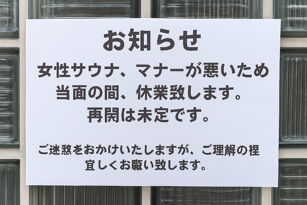 「お知らせ 女性サウナ、マナーが悪いため当面の間、休業します。再開は未定です。」と書かれた貼り紙のアップ
